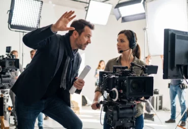 Film director speaking to a camera operator on a studio set
